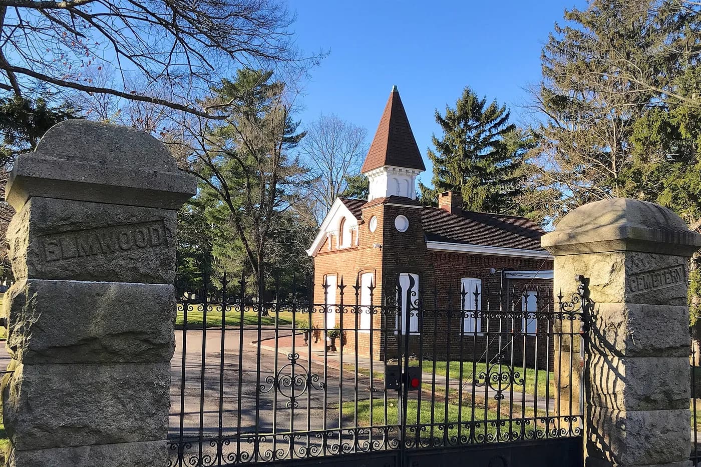 The stone gateposts and gatehouse at the entrance to Elmwood Cemetery.