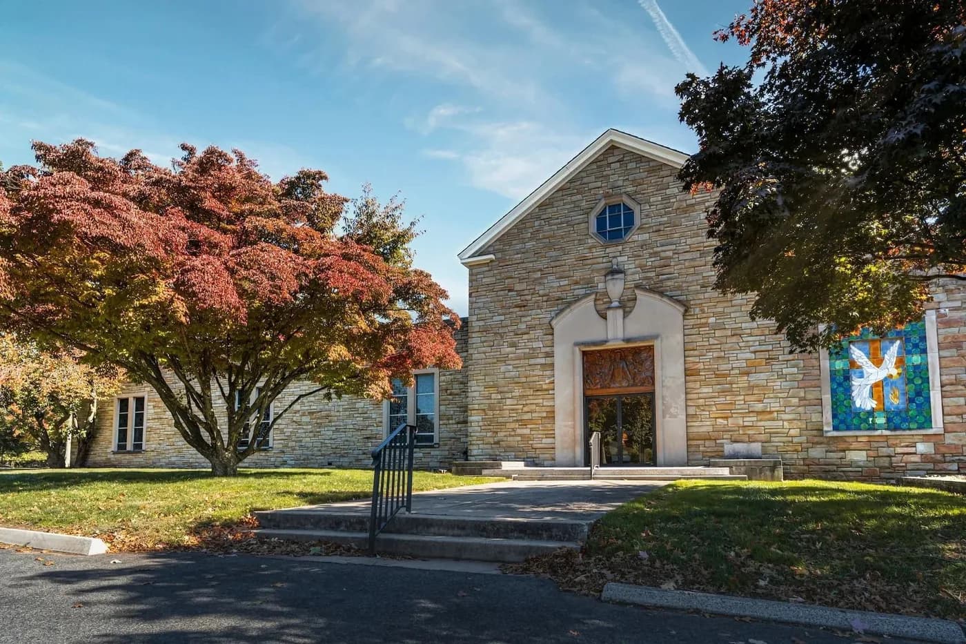 The stone chapel at Hollywood Memorial Park, framed by autumn trees.