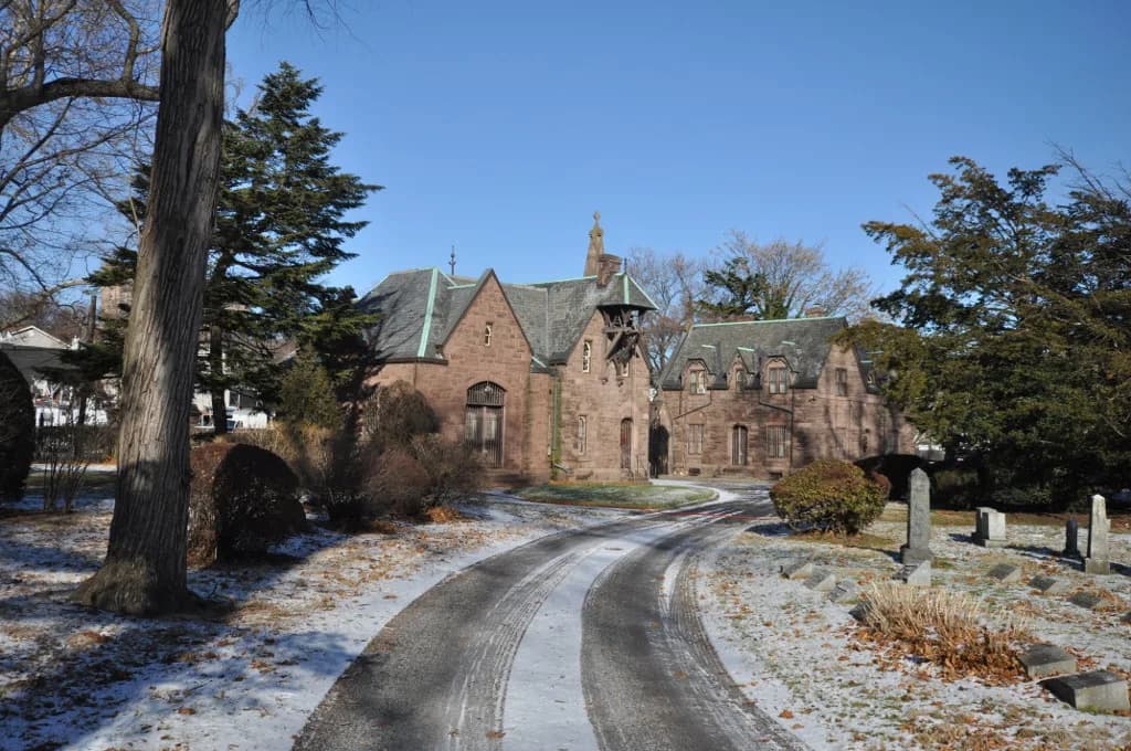 A drive through Mount Pleasant Cemetery leading to its brownstone gatehouse.