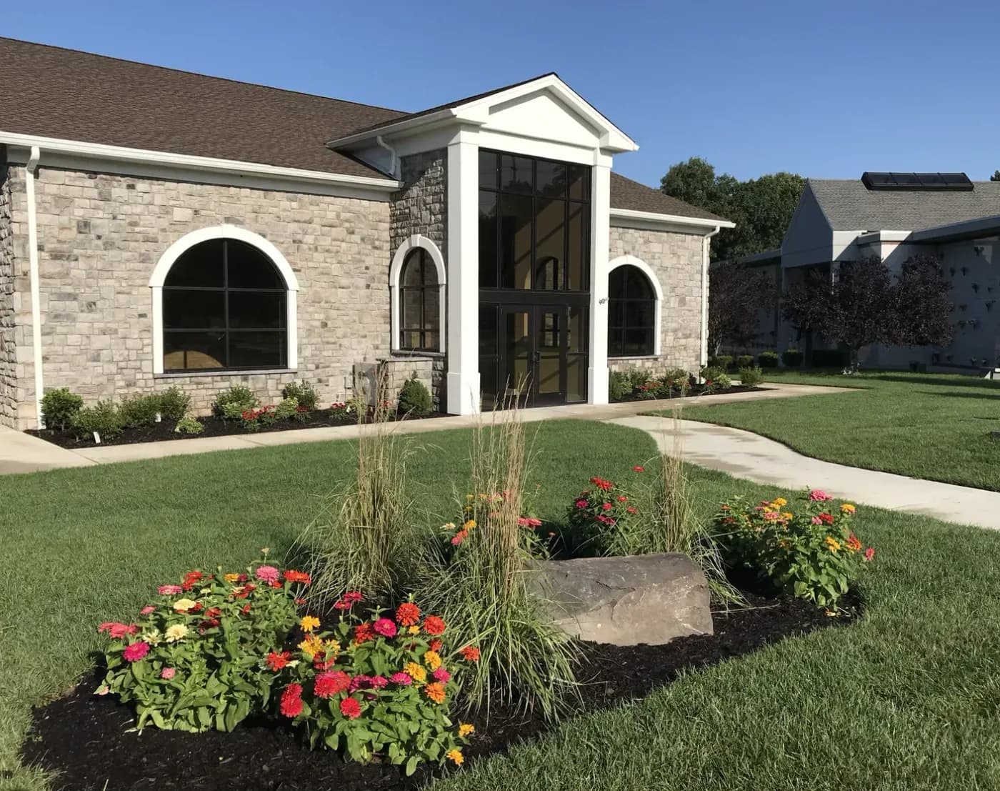 The stone-faced building and planted garden at Ocean County Memorial Park.